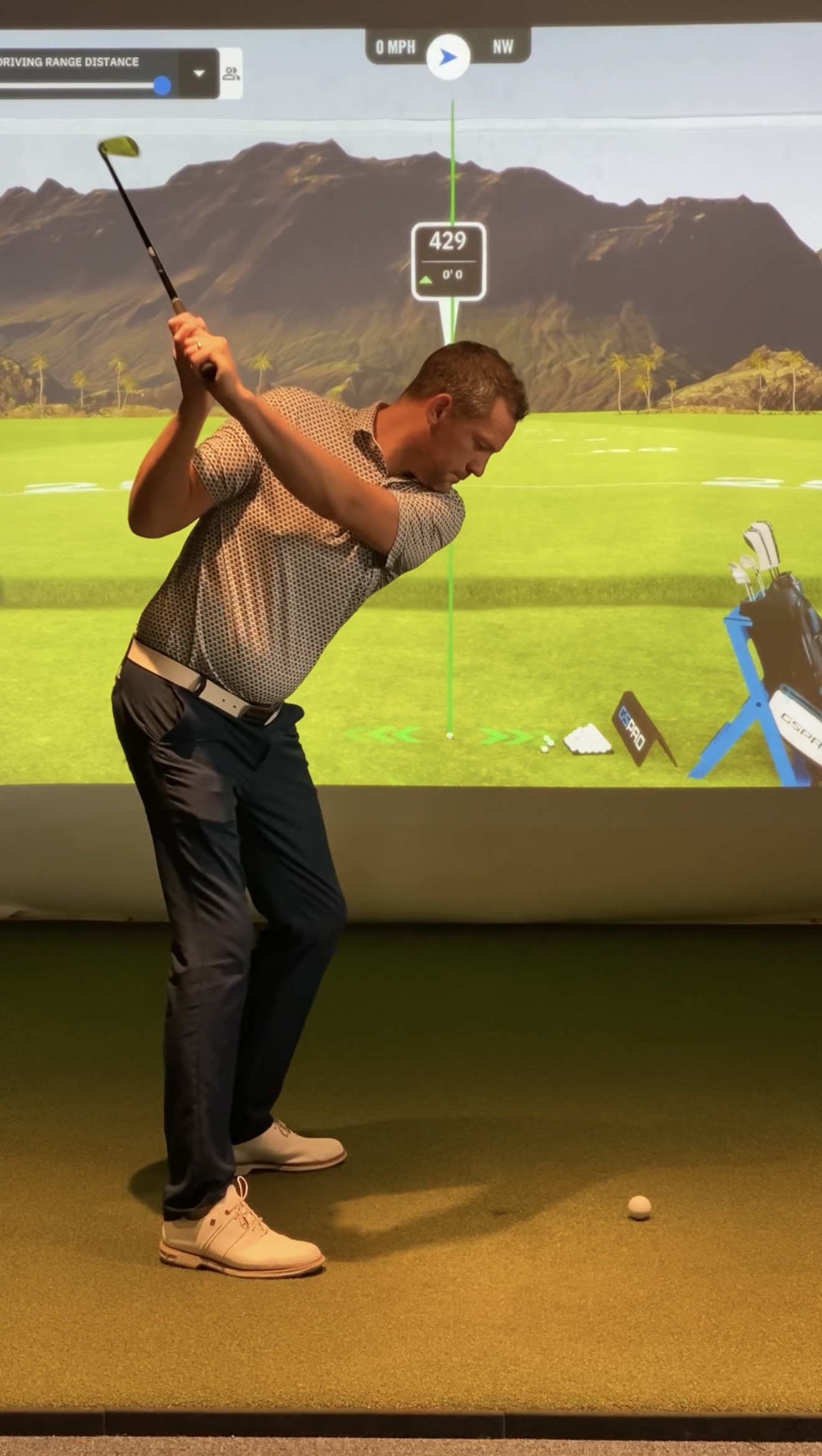 Jon Garratt at the top of his backswing, demonstrating in the Golf Evolution simulator bay